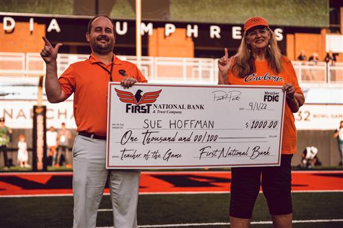 Sue Ann Hoffman receives a giant check as Teacher of the Game